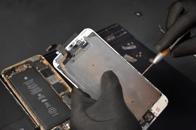 Technician lifting a phone display during a screen replacement